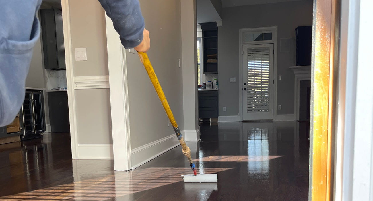 Hardwood floor screen and recoat service being applied to a dark wood floor