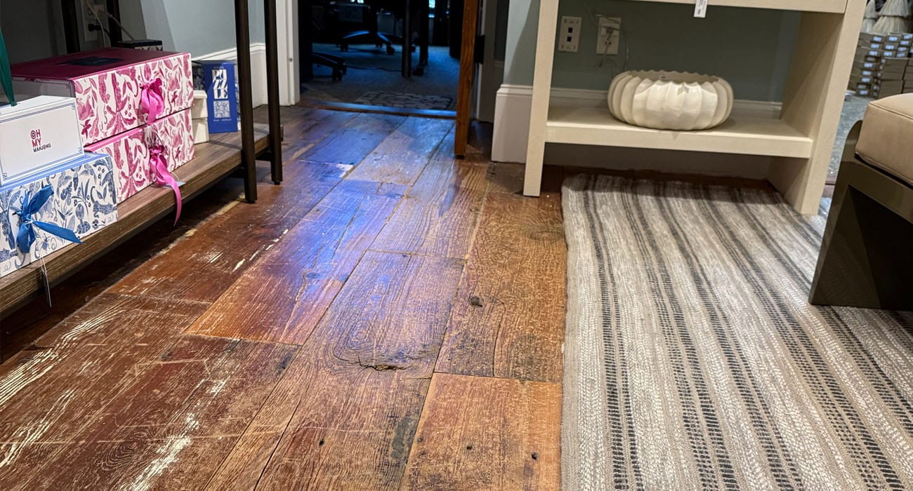 Worn hardwood floor finish before professional refinishing