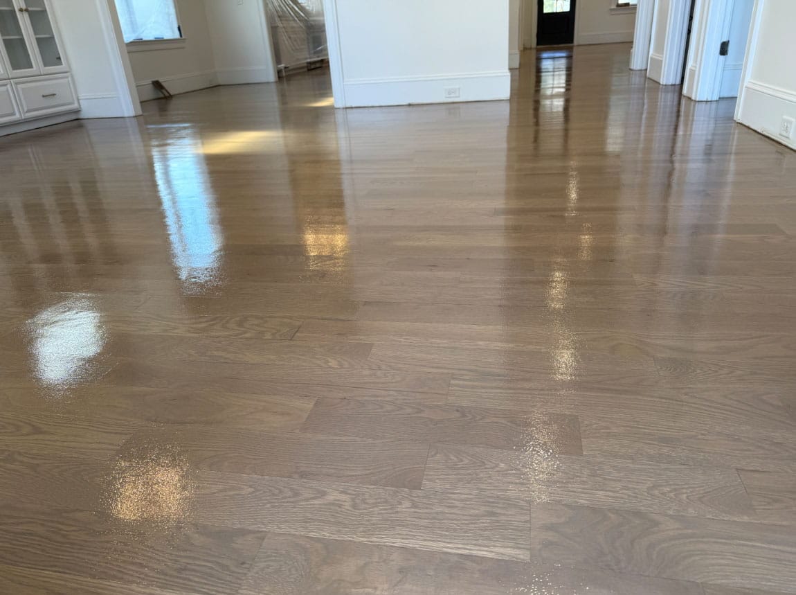 Refinished hardwood floor with smooth satin finish and visible wood grain in a bright Charlotte home.