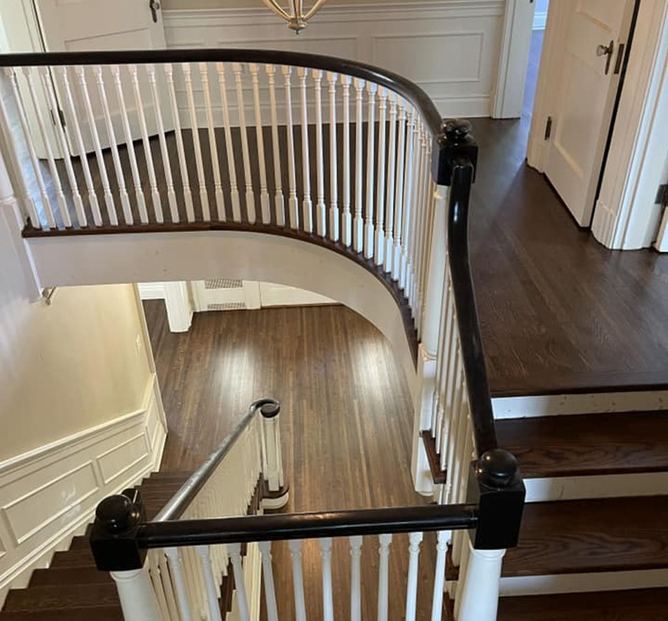 Beautiful hardwood staircase with dark wood flooring and white railings